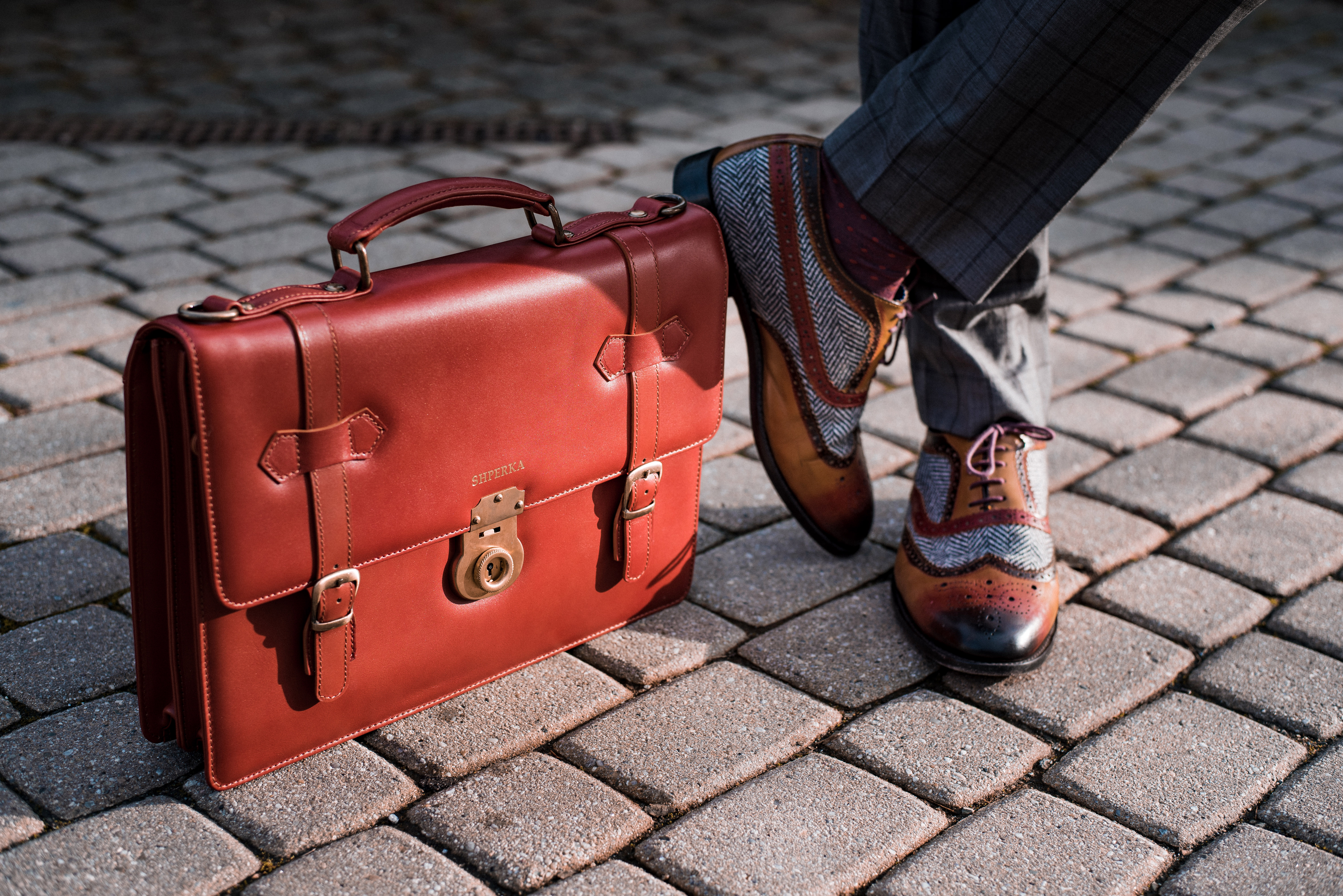 Hand-finished SHPERKA leather briefcase on cobblestones
